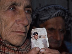 In this March 14, 2015, file photo, Makhni Begum holds a photograph of her son Shafqat Hussain in Muzaffarabad, Pakistan. (AP Photo/M.D. Mughal, File)