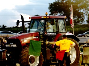 Nico Peeters takes the tractor he sold to Jim Morton out onto the straight-away at the Embro Tractor Pull in honour of Morton on Friday, July 31, 2015. Morton saved Peeters' life when he was stuck and knocked out inside of a corn silo last year.