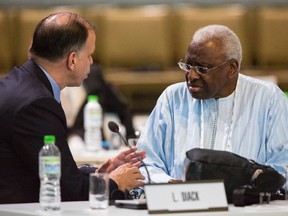 IAAF president Lamine Diack, right, speaks with a fellow IOC member during the 128th IOC session in Kuala Lumpur, Malaysia Monday, Aug. 3, 2015. Three weeks before the world championships, athletics was thrown into turmoil by new accusations of widespread doping. (Joshua Paul/AP Photo)