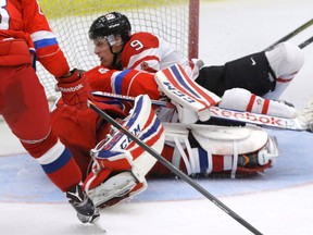 Canada's Mitch Marner crashes into Russia goalie Maxim Tretyak in a game on Monday. (Mike Drew/Postmedia Network)