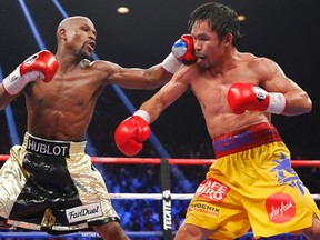 Floyd Mayweather, Jr. (left) lands a left to the face of Manny Pacquiao during their welterweight WBO, WBC and WBA title fight in Las Vegas, Nevada, in this May 2, 2015 file photo. (REUTERS/Steve Marcus/Files)