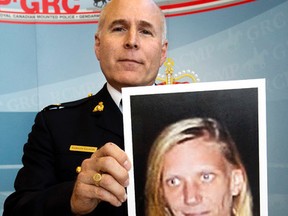 RCMP Inspector Gibson Glavin holds a photo of Corrie Renee Ottenbreit following a press conference at RCMP K Division, in Edmonton on July 28, 2015. (David Bloom/Postmedia Network)