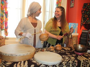 Kyoko Ogoda, left, founder of the Kings Don Taiko drumming group, and Wendy Luella Perkins, an organizer of the annual Hiroshima Day ceremony, to be held in McBurney Park on Thursday at 7 p.m. prepare for the ceremony in Kingston. (Michael Lea/The Whig-Standard)