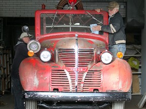 Volunteers Dave Reimer (l) and Leon St. Onge prepare a 1939 Fargo firetruck at the St. Vital Museum in Winnipeg, Man. Monday September 29, 2014 for a drive to its winter storage compound.