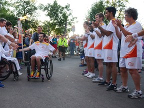 The 2015 Parapan Am Games Torch relay was carried by 18 local torchbearers during an afternoon community celebration held at Lake Ontario Park on Monday. The community cauldron was lit by local para-athletics athlete Brett Babcock, centre. (Julia McKay/The Kingston Whig-Standard/Postmedia Network