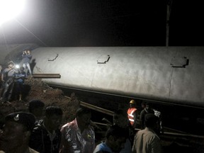Police and members of the rescue operation stand at the site of a train derailment near Harda, Madhya Pradesh in this handout provided by ANI on August 5, 2015. Two trains were derailed while they were crossing the Machak River, near Harda according local media. REUTERS/ANI/Handout via Reuters