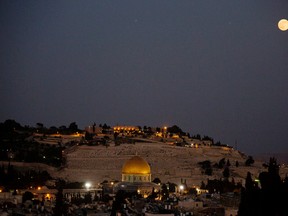 In this Saturday, July 12, 2014 file photo, a supermoon rises over Jerusalem's Old City and the Dome of the Rock  seen from the roof restaurant of the Notre Dame hotel. (AP Photo/Dusan Vranic, File)