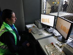 A customs inspector X-rays boxes of flowers packed for export and are ready to be loaded onto cargo planes to check for drugs before Valentine's Day at El Dorado International Airport in Bogota February 5, 2013. (REUTERS/John Vizcaino)