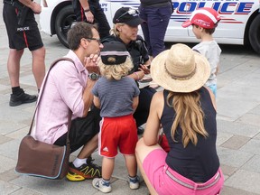 Philipp, Mattis and their parents speak with a Kingston Police officer at the Children’s Safety Village on Wednesday. (Anisa Rawhani/For The Whig-Standard)