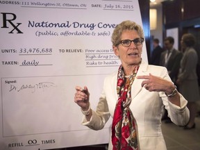 Ontario Premier Kathleen Wynne prepares to sign a poster supporting a national drug coverage at the summer meeting of Canada's premiers in St. John's on July 16, 2015. (THE CANADIAN PRESS/Andrew Vaughan)