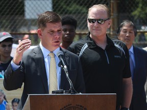 Boston mayor Martin J. Walsh, joined by former Boston Red Sox pitcher Curt Schilling, speaks during a press conference, Wednesday, Aug 5, 2015, about his proposal to ban snuff and chewing tobacco in city baseball fields, including Fenway Park. (Harrison Hill/The Boston Globe via AP)
