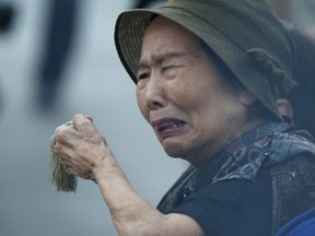 A woman reacts as she prays for the atomic bomb victims in front of the cenotaph for the victims of the 1945 atomic bombing, at Peace Memorial Park in Hiroshima, western Japan, August 6, 2015, on the 70th anniversary of the world's first atomic bombing of the city. Japan on Thursday marks the 70th anniversary of the attack on Hiroshima, where the U.S. dropped an atomic bomb on August 6, 1945, killing about 140,000 by the end of the year in a city of 350,000 residents. It was the world's first nuclear attack. The Atomic Bomb Dome, or Genbaku Dome, was the only structure left standing in this district of the city and has been preserved as a peace memorial.  REUTERS/Toru Hanai