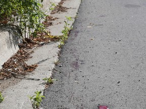 Spattered blood can be seen on Mountain Street where a man was assaulted in Sudbury, Ont. on Tuesday August 4, 2015. Gino Donato/Sudbury Star/Postmedia Network