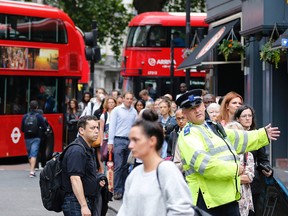 People queue up for bus transport at Victoria Station in London, Thursday, Aug. 6, 2015. A 24-hour strike of London tube workers continues over pay and conditions surrounding the planned introduction of overnight tube services. The Underground handles 4 million journeys a day, and the strike by members of four unions will likely paralyze the capital's transport system, despite extra bus and river services. (AP Photo/Frank Augstein)