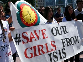 Women hold a banner during a demonstration marking the first anniversary of Islamic State's surge on Yazidis of the town of Sinjar, in front of the United Nations European headquarters in Geneva, Switzerland, August 3, 2015. REUTERS/Denis Balibouse