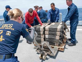 Coast Guard Cutter Stratton crew members secure cocaine bales from a self-propelled semi-submersible interdicted in international waters off the coast of Central America, in this U.S. Coast Guard picture taken July 19, 2015 and released August 5, 2015. The Coast Guard recovered more than 12,000 pounds (5,443 kgs) of cocaine worth an estimated $181 million wholesale from the 40-foot vessel, according to a Coast Guard news release.  Picture taken July 19, 2015.  (REUTERS/U.S. Coast Guard/Petty Officer 2nd Class LaNola Stone/Handout)