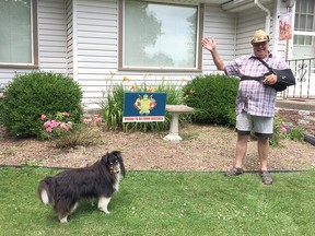 Ole Mardov poses in front of his home on Strathglass Street in Dresden, with his dog, Toby. A resident of the community for six years, he's trying to drum up some local pride by printing signs with the former town's crest. Handout/Postmedia Network