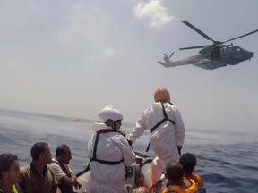 In this photo taken on Wednesday, Aug. 5, 2015 and made available Thursday, Aug. 6, an helicopter and a rescue boat work on the scene of the capsizing and sinking of a fishing boat crowded with migrants in the Mediterranean sea off Libya, Wednesday, Aug. 5, 2015. The Italian coast guard and Irish navy said at least 367 people were saved, although 25 bodies also were found in the latest human smuggling tragedy. (Marta Soszynska/MSF VIA AP Photo)