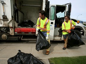 Edmonton Sun City Hall reporter David Lazzarino (left) and Joe Peden a garbage collector for Edmonton's Waste Management Services both collect bags on Thursday Aug 6, 2015. Lazzarino did a rode-a-long to experience the job. Tom Braid/Edmonton Sun