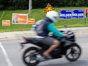 A collection of election signs for candidates in the London West riding have popped up at the intersection of Riverside Drive and Sanatorium Road in London. (CRAIG GLOVER, The London Free Press)