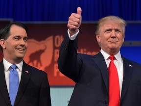 Real estate tycoon Donald Trump, right, and Wisconsin Gov. Scott Walker arrive on stage for the Republican presidential primary debate on August 6, 2015 at the Quicken Loans Arena in Cleveland, Ohio. AFP PHOTO/MANDEL NGAN