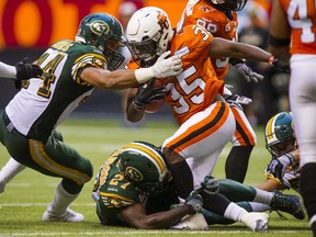 B.C Lions RB Shaq Murray-Lawrence is tackled by Eskimos LB Korey Jones,left and S Mike Dubuisson during Thursday’s game. (Reuters)