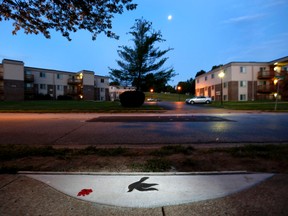 In this Sunday, Aug. 2, 2015, photo, a marker in the shape of a dove is embedded in the sidewalk near the spot where Michael Brown was shot and killed by police officer Darren Wilson in Ferguson, Mo. A year ago, Ferguson was thrust into the national spotlight after the death of Brown giving way to the "Black Lives Matter" movement. (AP Photo/Jeff Roberson)