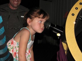 In this July 28, 2015, photo, Elizabeth “Lizzy” Myers, 5, gazes through a telescope at the Warren Rupp Observatory in Bellville, Ohio. Myers' parents have come up with a “bucket list” of things they want her to see before a rare condition causes her to lose her sight. (Kaitlin Durbin/News Journal via AP)