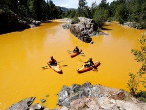 People kayak in the Animas River near Durango, Colo., Thursday, Aug. 6, 2015, in water colored from a mine waste spill. The U.S. Environmental Protection Agency said that a cleanup team was working with heavy equipment Wednesday to secure an entrance to the Gold King Mine. Workers instead released an estimated 1 million gallons of mine waste into Cement Creek, which flows into the Animas River. (Jerry McBride/The Durango Herald via AP)