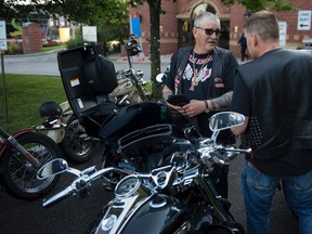 Members of various motorcycle clubs, including the Hells Angels, get their bikes ready outside a hotel in Toronto on Aug. 7, 2015. The group, in town to attend a funeral, were staying at the same hotel as Prime Minister Stephen Harper. (THE CANADIAN PRESS/Paul Chiasson)