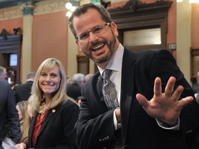 In this Jan. 14, 2015 photo, Rep. Cindy Gamrat, R-Plainwell, and Rep Todd Courser, R-Lapeer wave to reporters in the House of Representatives in Lansing. A Michigan House leader on Friday, Aug. 7, 2015 requested an investigation into allegations that Courser orchestrated the distribution of a fictional email claiming he had sex with a male prostitute in a bid to conceal an extramarital relationship.  In audio recordings obtained by the Detroit News, Courser  said the email was designed to create "a complete smear campaign" about him and Gamrat so a revelation about their relationship would seem "mild by comparison." (Dale G. Young /Detroit News via AP)
