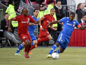Montreal Impact midfielder Patrice Bernier (8) moves the ball away from Toronto FC midfielder Collen Warner (26) and defender Justin Morrow (2) during play at BMO Field. (Dan Hamilton/USA TODAY Sports)