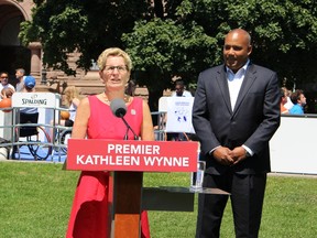 Premier Kathleen Wynne, flanked by Tourism, Culture, Sport Minister Michael Coteau, says she's going to make her voice heard in the ongoing federal election campaign. Wynne made the comment on Friday August 7 2015, standing outside of Queen's Park. (Toronto Sun/Antonella Artuso)