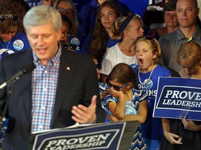 A girl yawns while standing behind Prime Minister Stephen Harper as he campaigns in Belleville, Ont. Friday, August 7, 2015. It was the sixth day in the 78-day election campaign. Luke Hendry/Belleville Intelligencer/Postmedia Network
