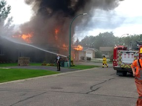 Firefighters battle a blaze at a pair of homes in Virden, Manitoba. At least one person is in hospital after two homes in Virden, Man., were destroyed by a fire that appears to have been sparked by an explosion on Friday, August 7, 2015.