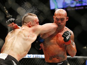 Rory MacDonald, left, and Robbie Lawler exchange blows in their welterweight title mixed martial arts bout at UFC 189 on Saturday, July 11, 2015. (AP Photo/John Locher)