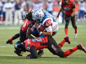 Montreal Alouettes Jea-Christophe Beaulieu (46) is taken down by Ottawa RedBlacks Brandon McDonald (22) and Abdul Kanneh (14) during the first half of a CFL game in Ottawa on Friday, Aug. 7, 2015. 
THE CANADIAN PRESS/Justin Tang