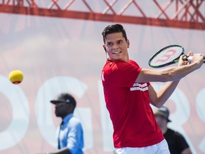 Milos Raonic returns a shot during an exhibition match on a tennis court atop a barge docked on Lake Ontario in Toronto on July 22, 2015. (THE CANADIAN PRESS/Aaron Vincent Elkaim)