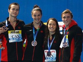 Yuri Kisil, Chantal van Landeghem, Sandrine Mainville and Santo Condorelli, from left, from Canada show off their bronze medals during the ceremony for the 4x100m freestyle mixed relay final at the Swimming World Championships in Kazan, Russia, Saturday, Aug. 8, 2015. (AP Photo/Sergei Grits)