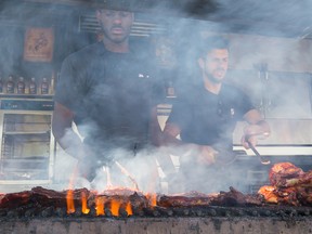 Cooks at Jack the Ribbers booth kick up a cloud of smoke as they barbecue racks of ribs at the 9th annual Quinte Ribfest on Sunday August 9, 2015 in Belleville, Ont. Tim Miller/Belleville Intelligencer/Postmedia Network