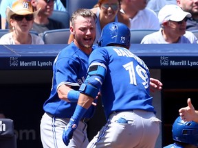 Josh Donaldson #20 of the Toronto Blue Jays congratulates Jose Bautista #19 after Bautista hit a solo home run in the fourth inning against the New York Yankees on August 9, 2015 at Yankee Stadium in the Bronx borough of New York City.  Elsa/Getty Images/AFP