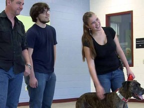 From left, Lloyd Goldston, left, and his children are reunited with their dog, Boozer, after a 9-year separation, in Golden, Colo. Boozer, now 10, went missing while the family was moving from Tennessee to Alabama. (KUSA via AP) MANDATORY CREDIT; DENVER METRO OUT