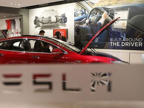 A man looks around Tesla Motors' Model S P85 in the Tesla showroom in Beijing in this Jan. 29, 2014, file photo.  REUTERS/Kim Kyung-Hoon/Files