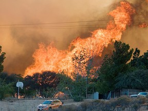 In this Friday, July 17, 2015 file photo, flames rise from a fire over a cluster of homes in Oak Hills, Calif. (James Quigg/The Victor Valley Daily Press via AP,File)