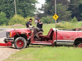 Constables Todd Trahan, left, and Scott Renders, members of the Chatham-Kent Police Service Traffic Unit, discuss the investigation into a fatal crash that claimed the life of a 22-year-old Dover Township man on Monday, Aug. 10, 2015. Police said the victim was pronounced dead at the scene after a southbound pickup truck on Winter Line Road lost control and ended up in a ditch near Pain Court, Ont. A passerby reported the crash just after 7 a.m. (Ellwood Shreve, The Daily News)