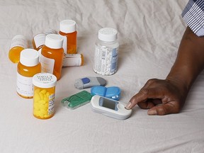 In this Monday, July 13, 2015 photo Earl Charles Williams Sr., 59, sits next to some of the medication he must take for his diabetes. .  (AP Photo/Christian K. Lee)