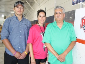 French River Rapids defenceman Eric Paquette, left, billet co-ordinator Tammy Seguin and assistant coach Denis Commanda stand next to the NOJHL expansion team's logo at Noelville Arena on Saturday. Ben Leeson/The Sudbury Star