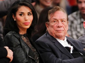 Clippers owner Donald Sterling, right, and V. Stiviano, left, watch the Clippers play the Lakers during a game in Los Angeles on Dec. 19, 2010. Sterling sued celebrity website TMZ and an ex-girlfriend over the recording of his off-colour remarks that cost him ownership of the Clippers. (Danny Moloshok/AP Photo/File)