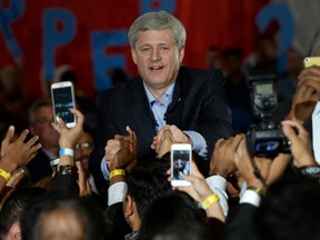 Conservative leader Stephen Harper shakes hands as supporters' smartphones capture the moment during a rally in Brampton, Ont., on Aug. 10, 2015. (THE CANADIAN PRESS/Sean Kilpatrick)