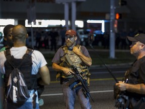 Members of the Oath Keepers walk with their personal weapons on the street during protests in Ferguson, Missouri August 11, 2015. Police in riot gear clashed with protesters who had gathered in the streets of Ferguson early on Tuesday to mark the anniversary of the police shooting of an unarmed black teen whose death sparked a national outcry over race relations. REUTERS/Lucas Jackson